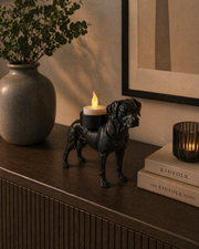 Zwarte Rhodesian Ridgeback waxinelichthouder met LED-waxinelichtje op donker kastje met vaas en decoratie langs de wand.